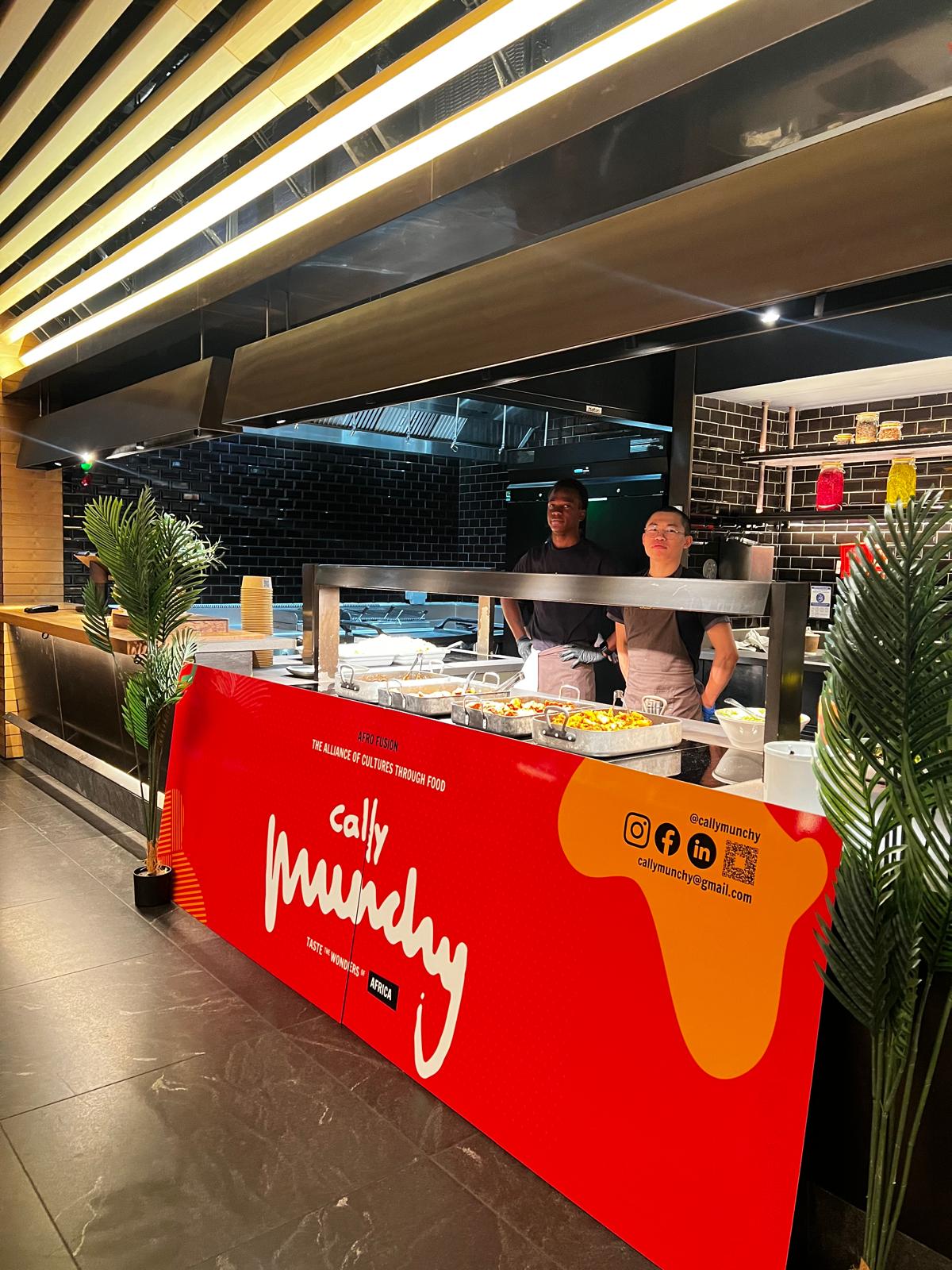 Cally Munchy branded serving counter with chefs plating Afro-fusion dishes